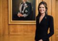 Louise Pragnell wears a brooch from her family's jewellery company as she stands alongside her second portrait of Princess Anne