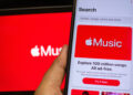 Apple Music displayed on smartphone with tablet with Apple Music logo in the background