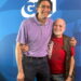 Two men pose for the camera in a side hug.