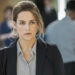 Riley Keough in "The Girlfriend Experience." A young white woman looks off in the distance. She is wearing business attire, and there are people in the background.