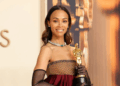 afro-latina actress poses with an Academy Award trophy at a red carpet event, celebrating her achievements in film.