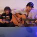 Two people sitting on a couch in Miami, one is reading a book and the other playing guitar.