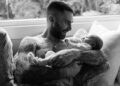 Adam Levine holding his baby