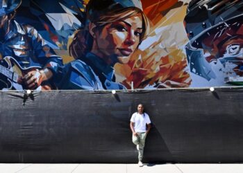 Miami-based artist Brian Peterson next to his mural at OC...