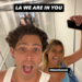 Two friends making playful faces while walking down a hallway, with text overlay saying "LA WE ARE IN YOU.