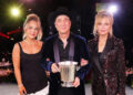 Lily Black, Clint Black and Lisa Hartman Black standing together and holding an award in Nashville.