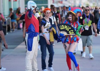 Dorian Reyes Black of Los Angeles, dressed as Peacemaker, from left, Connor Bright of Los Angeles, dressed as Archie from "Riverdale" and Emily Rose of Los Angeles, dressed as Pomni from "The Amazing Digital Circus" attend Comic-Con International on Thursday in San Diego. (AP Photo/Chris Pizzello)