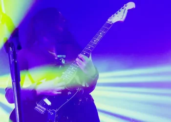 strobe lights filter a guitarist in blue and yellow lighting