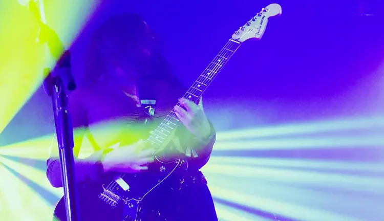 strobe lights filter a guitarist in blue and yellow lighting