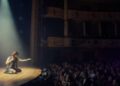 audience in a theater watching actor on stage