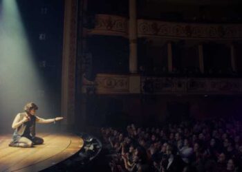 audience in a theater watching actor on stage