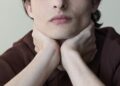 Finn Wolfhard posing with head in hands