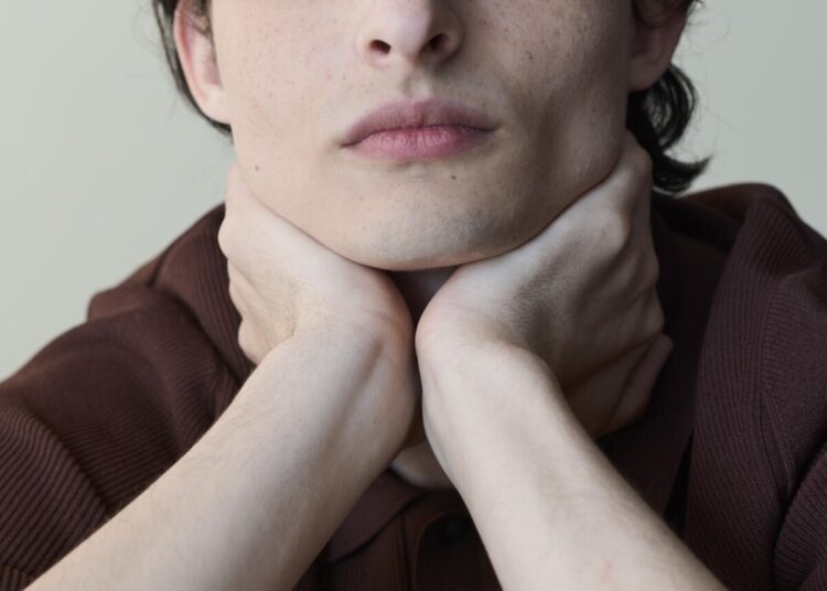 Finn Wolfhard posing with head in hands