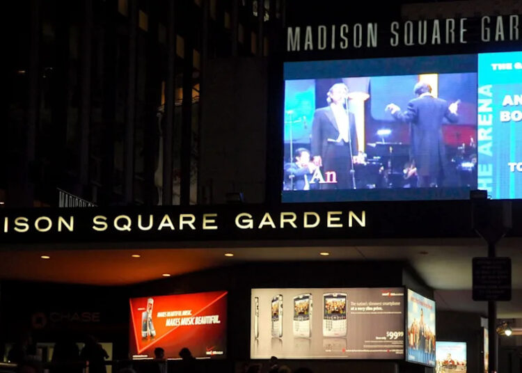 A marquee at Madison Square Garden advertising an Andrea Bocelli concert, with bright digital displays.