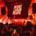 Photo of a party with red lights and an LED sign that reads Perro Negro