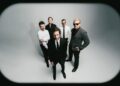 Interpol stare down AI on atmospheric new single 'Iron City'