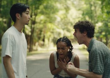 Three young people arguing on a forest road, with one person shouting and others showing emotional distress.