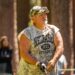 Larry the Cable Guy wearing a camouflage shirt and hat, playing golf.