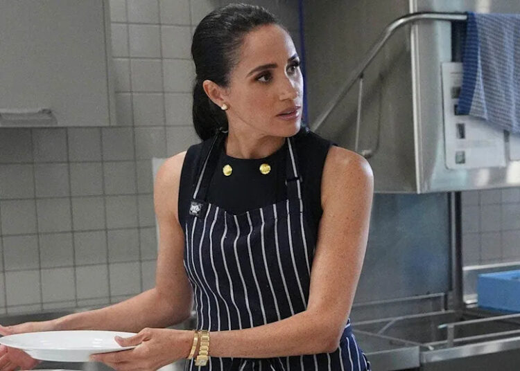 Meghan, Duchess of Sussex serves lunch with a staff member at a women's shelter in Melbourne.