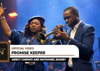 Mercy Chinwo raising her hand in worship next to Nathaniel Bassey playing the trumpet in the official Promise Keeper music video.