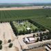 Darren Schmall’s ApCal Rock’N Ranch, the popular outdoor venue north of Fresno, photographed Friday, July 10, 2026 near Madera. Parking is seen at the bottom left along Road 32, surrounded by orchards and the main concert venue in the center.