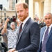 Prince Harry leaving Chatham House in London with security behind him.