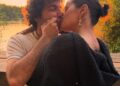 A couple sharing a romantic kiss at sunset by a lakeside, surrounded by nature.