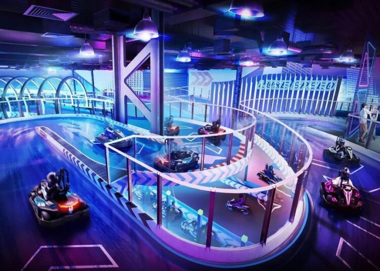 Indoor go-kart track with neon lights and multiple racers on a curved track.