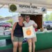 A man and woman pose for a photo at a farm stand at the Electric City Farmers Market in Scranton, PA.
