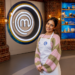 cook wearing apron in a kitchen studio with masterchef logo in background.