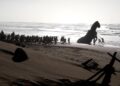 Men pull the Trojan Horse on a beach in "The Odyssey."