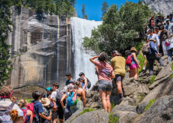 Hikers crowd together to get a view of Vernal Fall on Yosemite National Park’s Mist Trail on a busy Memorial Day weekend, Saturday, May 23, 2026.