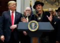 President Donald Trump looks on as musician Kid Rock speaks during a 2018 signing ceremony at the White House.