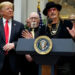 President Donald Trump looks on as musician Kid Rock speaks during a 2018 signing ceremony at the White House.