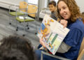 Christie Cole reads book about well-behaved dinosaurs at school.