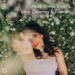 A woman in a light dress lies on grass surrounded by white flowers, reaching toward the camera. Text reads: Hold These Truths Lara Downes & Friends.