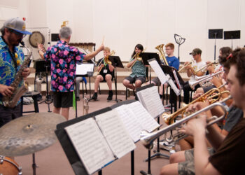 A director leading jazz musicians during a rehearsal.