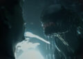 A Xenomorph standing menacingly in front of a scared person in Alien Romulus
