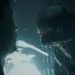 A Xenomorph standing menacingly in front of a scared person in Alien Romulus