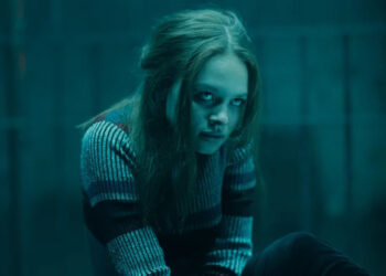 Beatrix glowering in a dark room