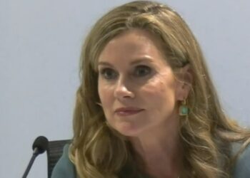 Julie Inman Grant speaking at the RC, wearing a blue blazer, green earrings, smiling softly.