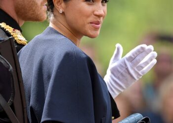 No momento em que o príncipe Harry repreendeu Meghan Markle como um 'garoto travesso' na varanda do palácio de Buckingham, de acordo com um especialista em linguagem corporal