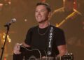 O vencedor do 'American Idol', Scott McCreery, cai para trás no palco durante o show