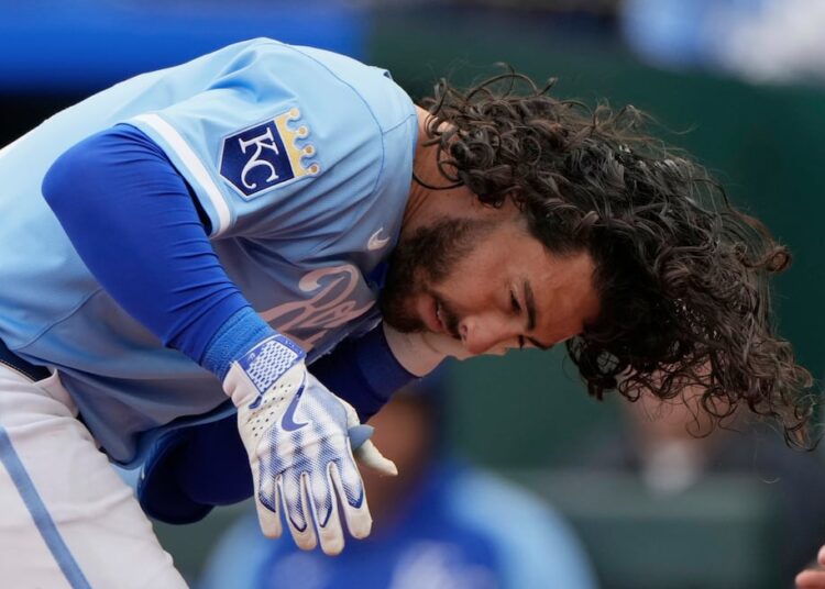 Jonathan India, da Kansas City Royals, segura sua mandíbula depois que ele foi atingido por um campo jogado por ...