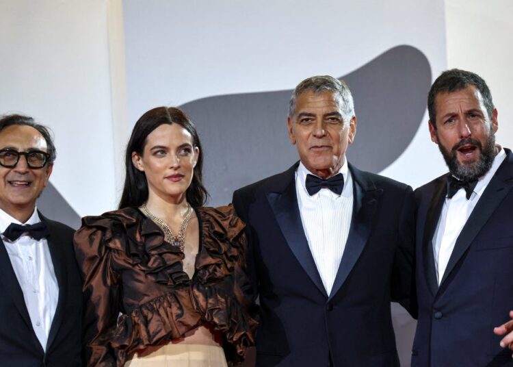 Adam Sandler usa smoking raro no tapete vermelho com George Clooney