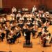 A orquestra realiza o desempenho no palco.