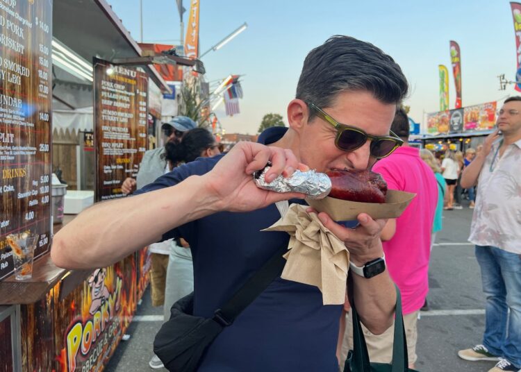 O escritor de viagens de Globe Christopher Muther comendo uma perna de peru no Big E. do ano passado