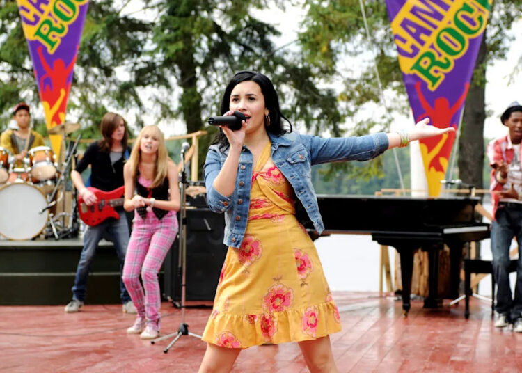 Demi Lovato está em sua 'Era do Produtor' no set de 'Camp Rock 3', enquanto os fãs imploram para reprisar o papel de Mitchie