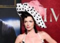 Julia Fox canais dos anos 90 em vestido de espartilho e chapéu de penas
