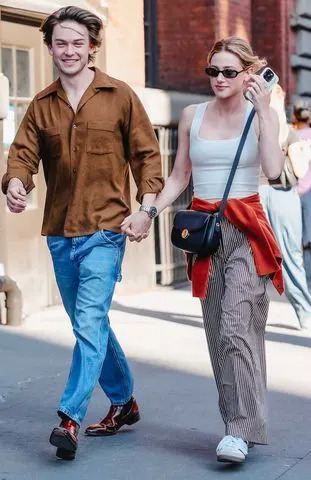 Lili Reinhart e Jack Martin sorriem enquanto dão as mãos em uma caminhada romântica na cidade de Nova York